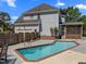 Private in-ground pool with brick trim and concrete patio sits behind the house and next to the back porch at 1420 Norwood Crest Ct, Raleigh, NC 27614