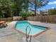 Backyard pool is surrounded by concrete and wood fencing with mature trees and vegetation at 1420 Norwood Crest Ct, Raleigh, NC 27614