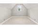 Finished attic bedroom space with neutral carpeting, trim, and paint with a single dormer window at 1420 Taylor Farm Rd, Raleigh, NC 27603