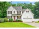 Charming two-story home with manicured lawn, red door, and mature landscaping at 1420 Taylor Farm Rd, Raleigh, NC 27603