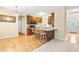 Open-concept kitchen with wood cabinets, an island with bar seating, and hardwood flooring at 1420 Taylor Farm Rd, Raleigh, NC 27603