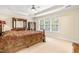 Spacious main bedroom with tray ceiling, large windows, and carpet flooring at 1420 Taylor Farm Rd, Raleigh, NC 27603