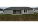 Backyard featuring a patio, gray siding, dark roof, and green grass at 151 Oakfield Trace Dr, Four Oaks, NC 27524