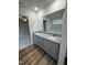 Bathroom with double sinks, granite counters, wood-look floors, and access to bedroom at 151 Oakfield Trace Dr, Four Oaks, NC 27524