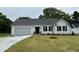 Charming single-story home with a gray exterior, manicured lawn, and attached garage offers modern curb appeal at 151 Oakfield Trace Dr, Four Oaks, NC 27524