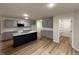 Modern kitchen boasts gray cabinets, stainless steel appliances, a spacious island, and stylish hardwood flooring throughout at 151 Oakfield Trace Dr, Four Oaks, NC 27524