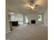 Spacious living room featuring plush carpeting, a fireplace, and ample natural light with an open view to the kitchen at 151 Oakfield Trace Dr, Four Oaks, NC 27524