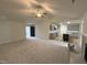 Open-concept living room with view to the kitchen featuring sleek gray cabinets and an island, seamlessly connecting living spaces at 151 Oakfield Trace Dr, Four Oaks, NC 27524