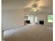 Bright, open-concept living room with a ceiling fan, fireplace, and views of the kitchen creating a welcoming atmosphere at 151 Oakfield Trace Dr, Four Oaks, NC 27524