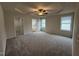 Generous main bedroom featuring a tray ceiling, ceiling fan, and access to the ensuite bathroom and walk-in closet at 151 Oakfield Trace Dr, Four Oaks, NC 27524