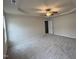 Spacious main bedroom featuring a tray ceiling, ceiling fan, neutral walls, and plush carpet at 151 Oakfield Trace Dr, Four Oaks, NC 27524
