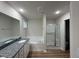 Bright bathroom featuring granite counters, soaking tub, and glass enclosed shower at 188 Oakfield Trace Dr, Four Oaks, NC 27524