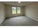 This bedroom has neutral walls and carpet, along with a double window at 188 Oakfield Trace Dr, Four Oaks, NC 27524