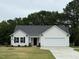 Inviting one-story home with a classic white facade, black trim, and an attached two-car garage at 188 Oakfield Trace Dr, Four Oaks, NC 27524