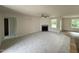 Large living room with a fireplace, carpet flooring, and plenty of natural light from the windows at 188 Oakfield Trace Dr, Four Oaks, NC 27524