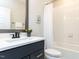 Stylish bathroom with a combination shower and bathtub, dark vanity, and modern fixtures at 2008 Van Hook Ln, Apex, NC 27502