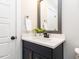 Bathroom featuring black vanity with white countertop and black hardware and a gray framed mirror at 2008 Van Hook Ln, Apex, NC 27502