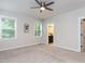 Bright carpeted bedroom featuring a ceiling fan, multiple windows, and an ensuite bathroom at 2008 Van Hook Ln, Apex, NC 27502