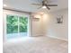 Bright bedroom featuring neutral walls, a ceiling fan, and a sliding glass door to a balcony with wooded view at 2008 Van Hook Ln, Apex, NC 27502
