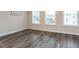 Empty room with hardwood flooring, base-molding, and three windows that let in plenty of natural light at 2008 Van Hook Ln, Apex, NC 27502