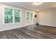 A well lit living room with beautiful floors, large windows, and a glass paneled door leading to a deck at 2008 Van Hook Ln, Apex, NC 27502