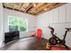 Finished basement room featuring bright natural light from a large window, vinyl flooring, and an exercise bike at 213 Preatonwood Dr, Apex, NC 27539