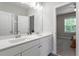 Bathroom with double vanity and white cabinets, alongside a connected bedroom view at 213 Preatonwood Dr, Apex, NC 27539