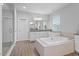 Bright bathroom featuring a soaking tub, granite countertops, and a separate shower at 213 Preatonwood Dr, Apex, NC 27539