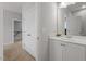 Bright bathroom with dual sinks, white cabinets, and a large mirror at 213 Preatonwood Dr, Apex, NC 27539