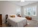 Comfortable bedroom with a large window, neutral carpet, and decorative pillows on the bed at 213 Preatonwood Dr, Apex, NC 27539