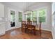 Sun-filled dining area with hardwood floors, views of the backyard, and modern lighting at 213 Preatonwood Dr, Apex, NC 27539
