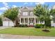 Charming brick home featuring a covered front porch, well-maintained landscaping, and a two-car garage at 213 Preatonwood Dr, Apex, NC 27539