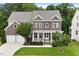 Charming brick two-story home featuring a covered front porch and well-manicured lawn and a two car garage at 213 Preatonwood Dr, Apex, NC 27539