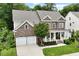 Beautiful brick front home featuring a covered porch, mature landscaping, and a two-car garage at 213 Preatonwood Dr, Apex, NC 27539