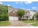 Brick front home with white columned porch, showcasing curb appeal and two-car garage at 213 Preatonwood Dr, Apex, NC 27539