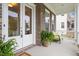Inviting covered porch featuring a cozy seating area and double glass front doors at 213 Preatonwood Dr, Apex, NC 27539