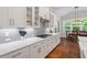 Bright kitchen featuring stone countertops, modern appliances, and hardwood floors at 213 Preatonwood Dr, Apex, NC 27539
