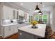 Well-lit kitchen with a large island, modern appliances, and easy access to the dining area at 213 Preatonwood Dr, Apex, NC 27539