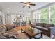 Spacious living room with hardwood floors, large windows, and an open layout to kitchen at 213 Preatonwood Dr, Apex, NC 27539