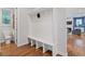 View of the mudroom, featuring a built-in bench with coat hooks and wood floors at 213 Preatonwood Dr, Apex, NC 27539