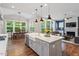 Open concept kitchen, living and dining space featuring many windows and stainless steel appliances at 213 Preatonwood Dr, Apex, NC 27539