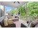 Screened porch featuring comfortable seating and a serene view of the surrounding trees at 213 Preatonwood Dr, Apex, NC 27539