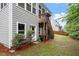 Back of the house with a stairway to the porch and a view of the green lawn at 213 Preatonwood Dr, Apex, NC 27539