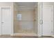 Modern shower with pebble flooring, glass door, and tiled walls at 213 Preatonwood Dr, Apex, NC 27539