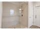 Tiled shower with pebble flooring, glass door, and tiled walls at 213 Preatonwood Dr, Apex, NC 27539