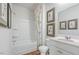 Bathroom features white vanity with dual sinks, shower, and decorative artwork at 2132 Monk Dr, Haw River, NC 27258