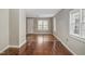 Bright living room with hardwood floors, several large windows, and an open layout, offering versatility at 230 Park Ave, Rocky Mount, NC 27801
