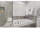 Bright bathroom featuring a soaking tub with tile surround and fresh white towels at 248 Daniel Ridge Rd, Wendell, NC 27591