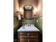 Stylish powder room featuring wallpaper, marble countertop, and unique mirror and lighting at 2637 Sidford Aly, Raleigh, NC 27608