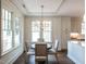 Cozy dining area featuring modern chandelier, large windows, hardwood floors, and adjacent kitchen space at 2637 Sidford Aly, Raleigh, NC 27608
